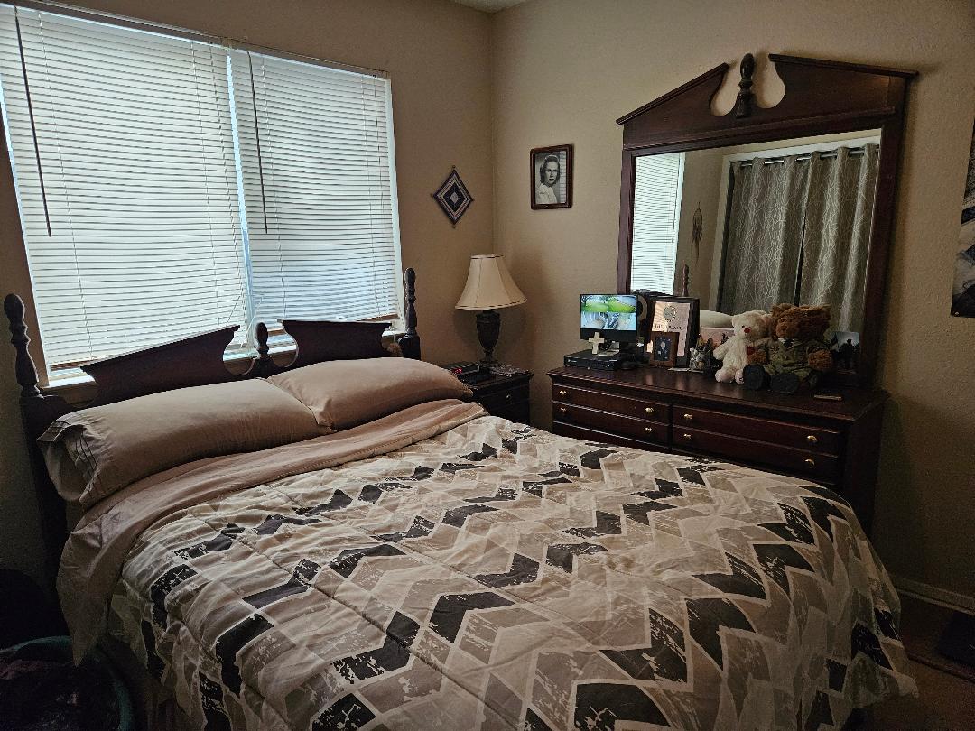 817 Lexington Road Elgin, TX 78621 - Photo 19 of 20 a bedroom with a bed and a dresser with mirror