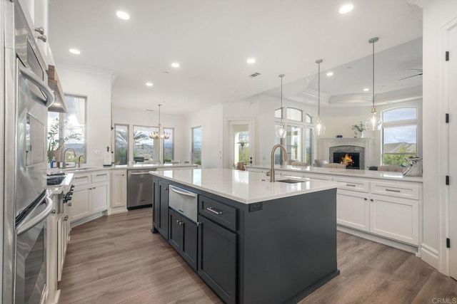 a large kitchen with stainless steel appliances granite countertop a lot of counter space and wooden floors