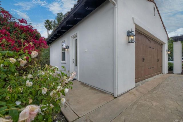 an aerial view of residential house with green space and fog