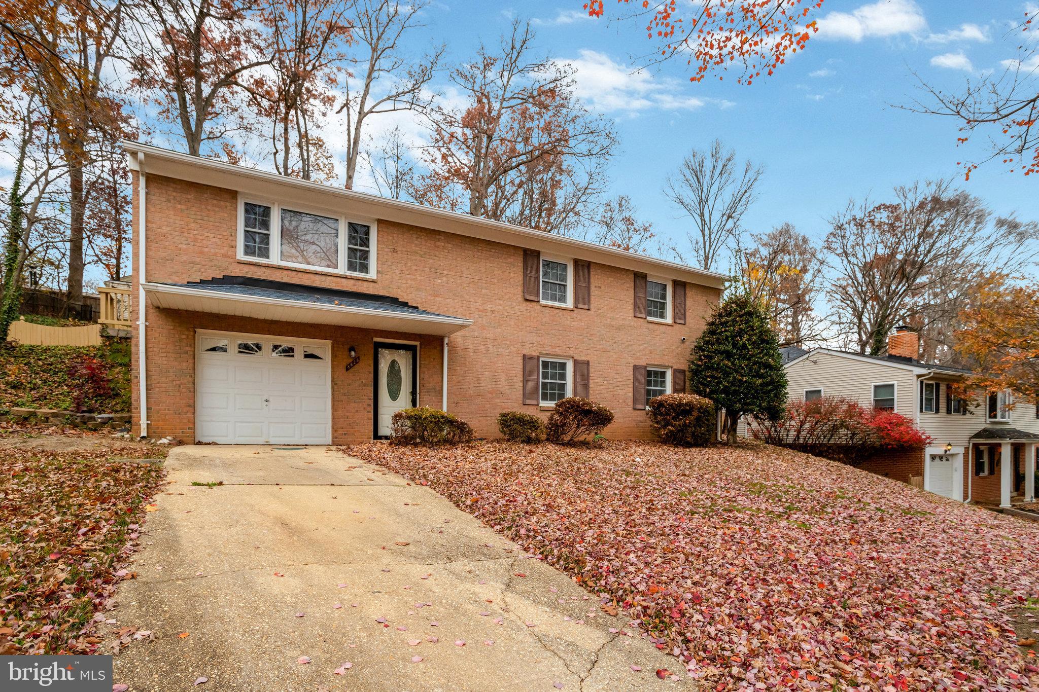 8626 Kerry Lane Springfield, VA 22152 - Photo 2 of 48 a front view of a house with a yard covered with snow in front of house
