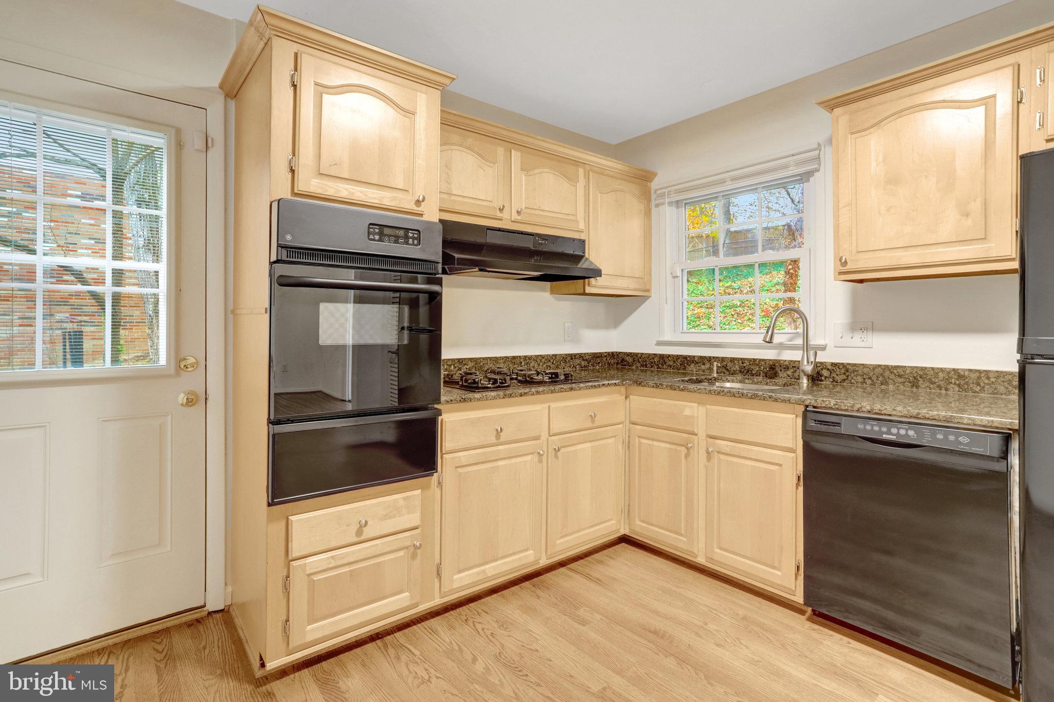 8626 Kerry Lane Springfield, VA 22152 - Photo 24 of 48 a kitchen with granite countertop white cabinets and white appliances