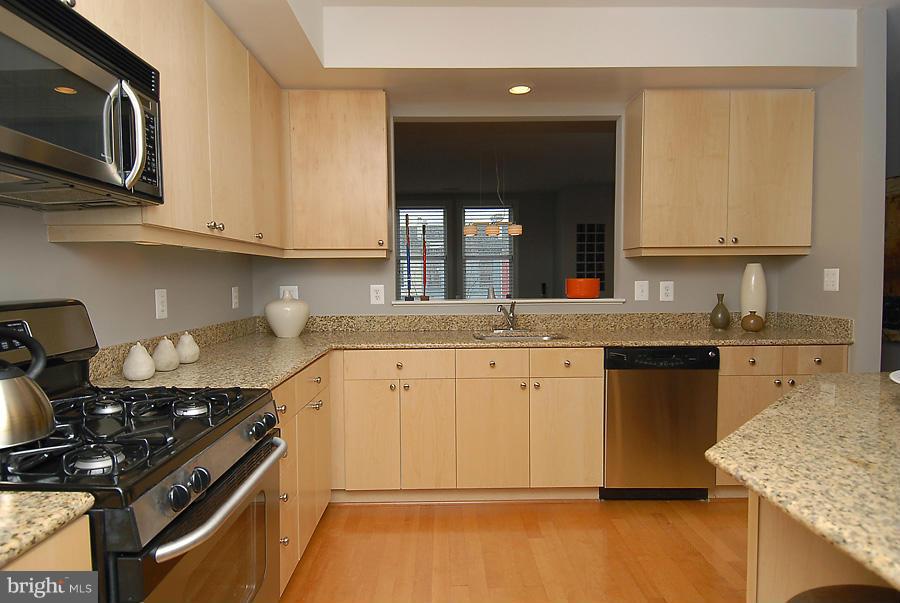 1360 Monroe Street Northwest, Unit B Washington, DC 20010 - Photo 5 of 19 a kitchen with stainless steel appliances granite countertop a stove a sink and a microwave
