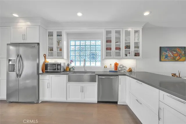 a kitchen with granite countertop a sink stainless steel appliances and cabinets