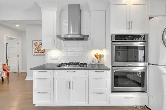 a kitchen with granite countertop white cabinets and white appliances