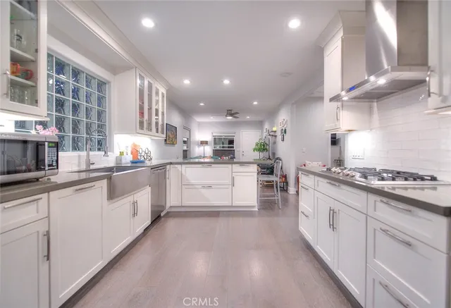 a large kitchen with stainless steel appliances granite countertop a stove a sink and a refrigerator