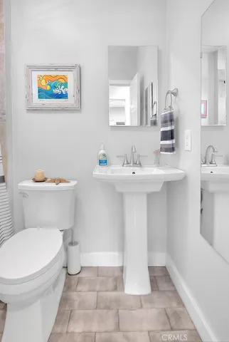 a bathroom with a toilet a sink and mirror