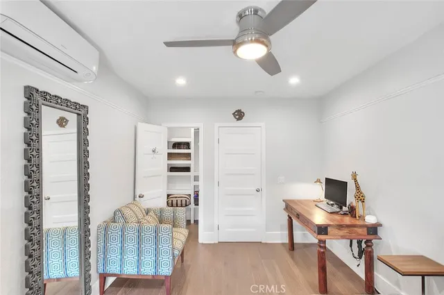 a view of a workspace with furniture and wooden floor