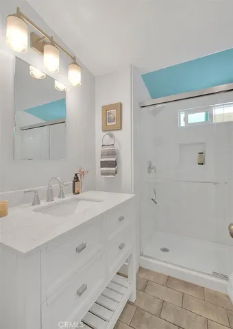 a bathroom with a sink a shower and a mirror