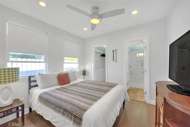 a bedroom with a bed and a flat tv screen on dresser