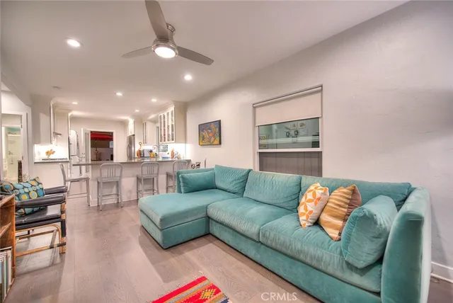 a living room with furniture and a view of kitchen