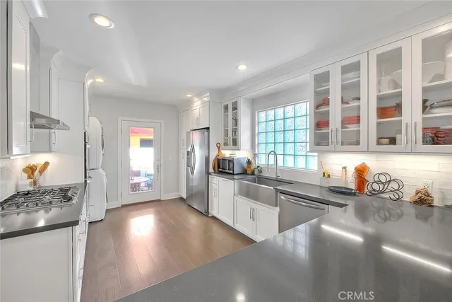a kitchen with stainless steel appliances granite countertop a sink stove and cabinets