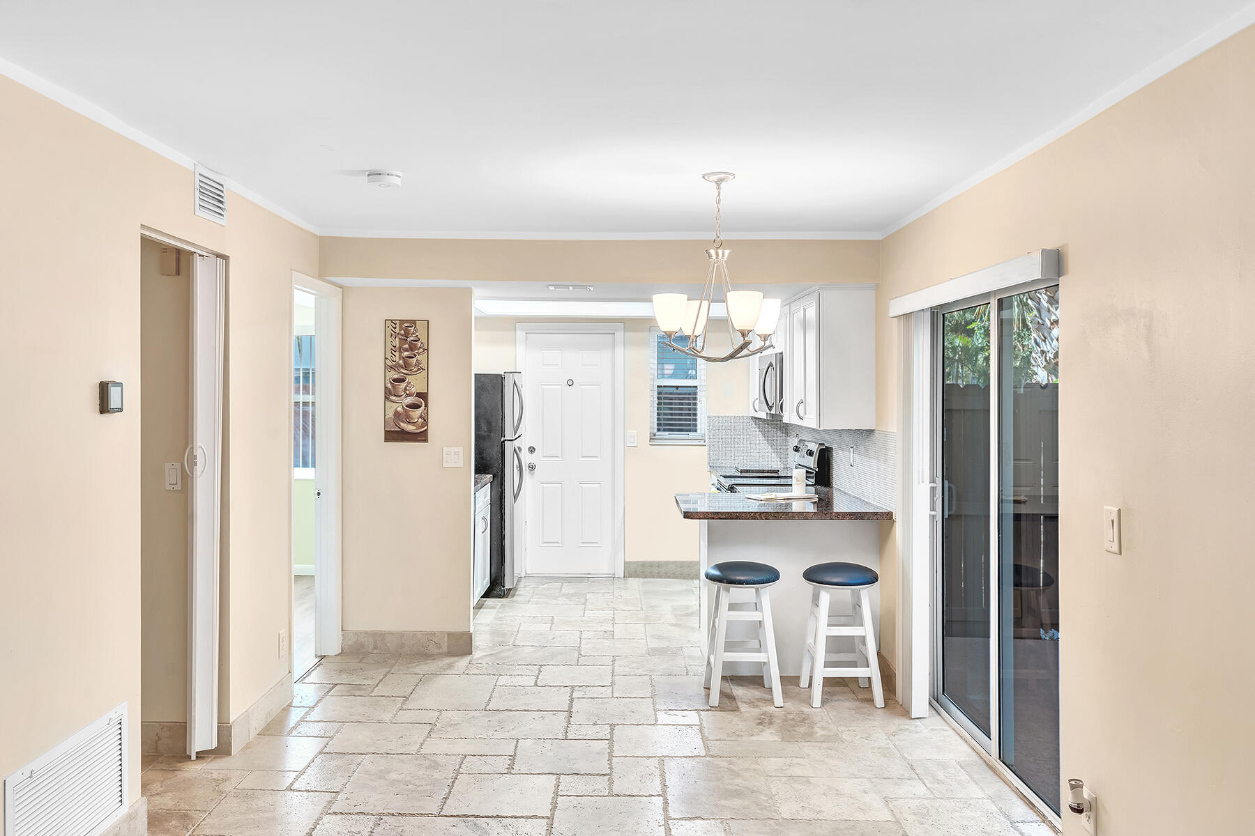 1945 Northwest 4th Avenue, Unit 32C Boca Raton, FL 33432 - Photo 15 of 52 a living room with kitchen island furniture and a chandelier