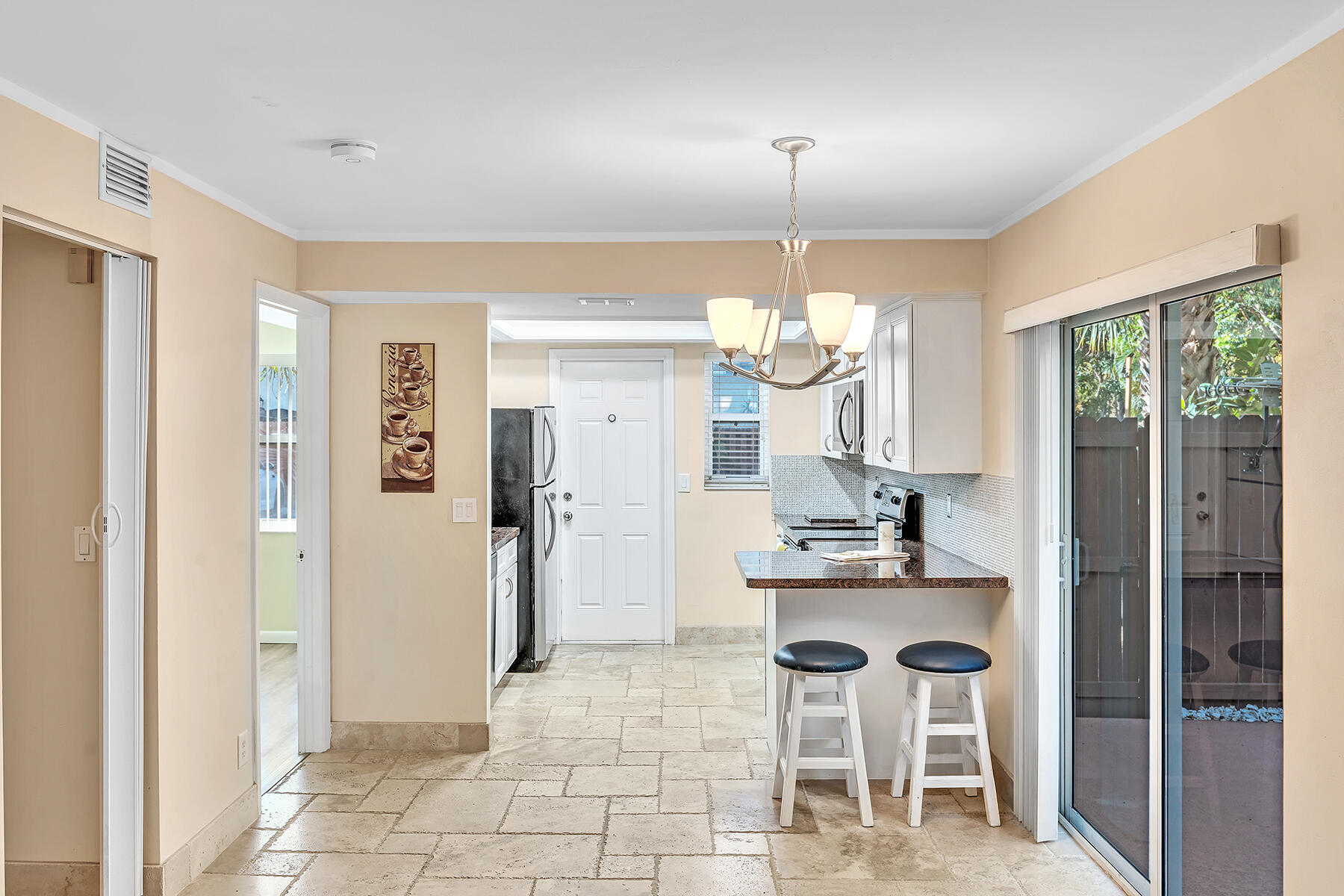 1945 Northwest 4th Avenue, Unit 32C Boca Raton, FL 33432 - Photo 16 of 52 a kitchen with a chandelier a refrigerator and a sink