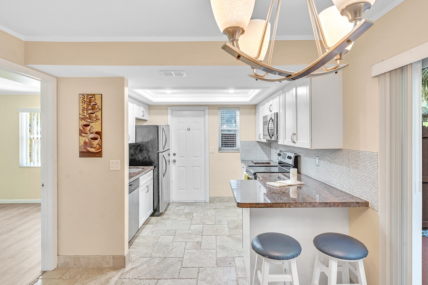 1945 Northwest 4th Avenue, Unit 32C Boca Raton, FL 33432 - Photo 19 of 52 a kitchen with stainless steel appliances granite countertop a sink a stove a refrigerator cabinets and chairs