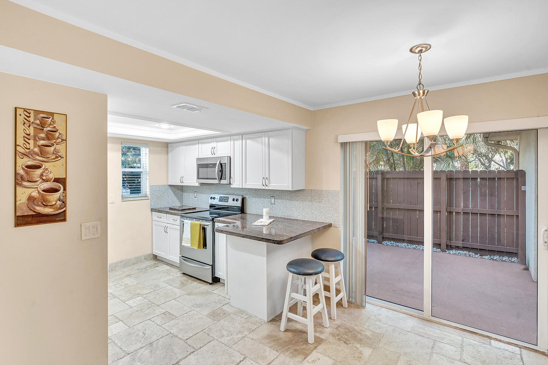 1945 Northwest 4th Avenue, Unit 32C Boca Raton, FL 33432 - Photo 22 of 52 a kitchen with stainless steel appliances granite countertop a stove top oven a sink dishwasher and a refrigerator