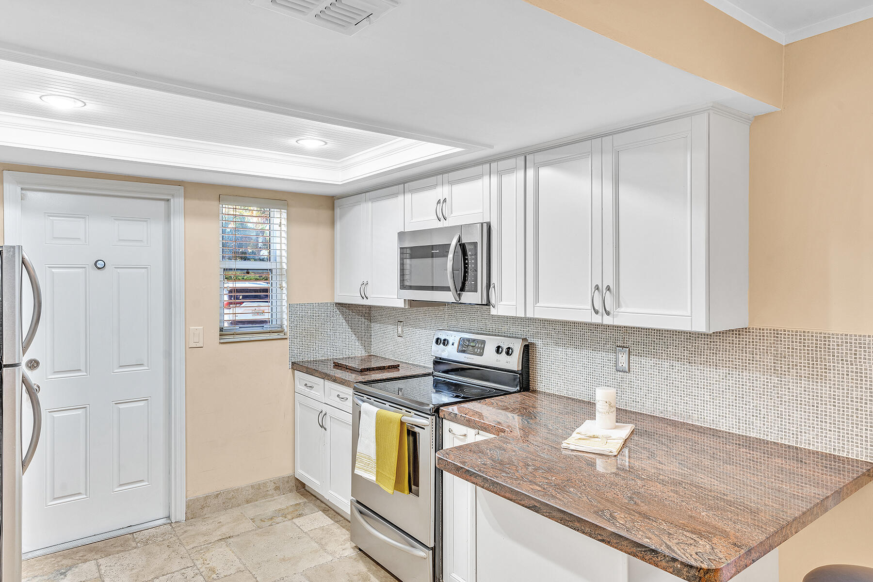 1945 Northwest 4th Avenue, Unit 32C Boca Raton, FL 33432 - Photo 23 of 52 a kitchen with stainless steel appliances granite countertop a stove a sink and a refrigerator