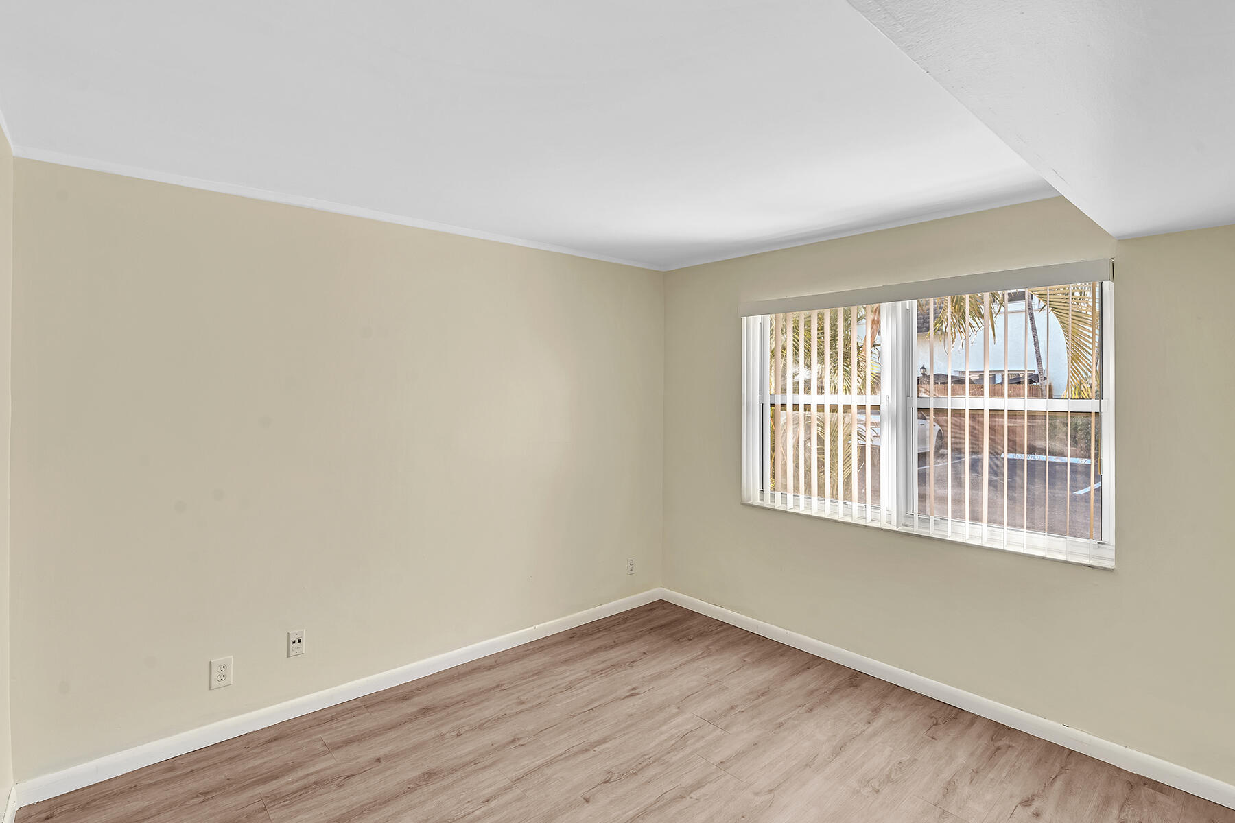 1945 Northwest 4th Avenue, Unit 32C Boca Raton, FL 33432 - Photo 27 of 52 a view of an empty room with wooden floor and a window