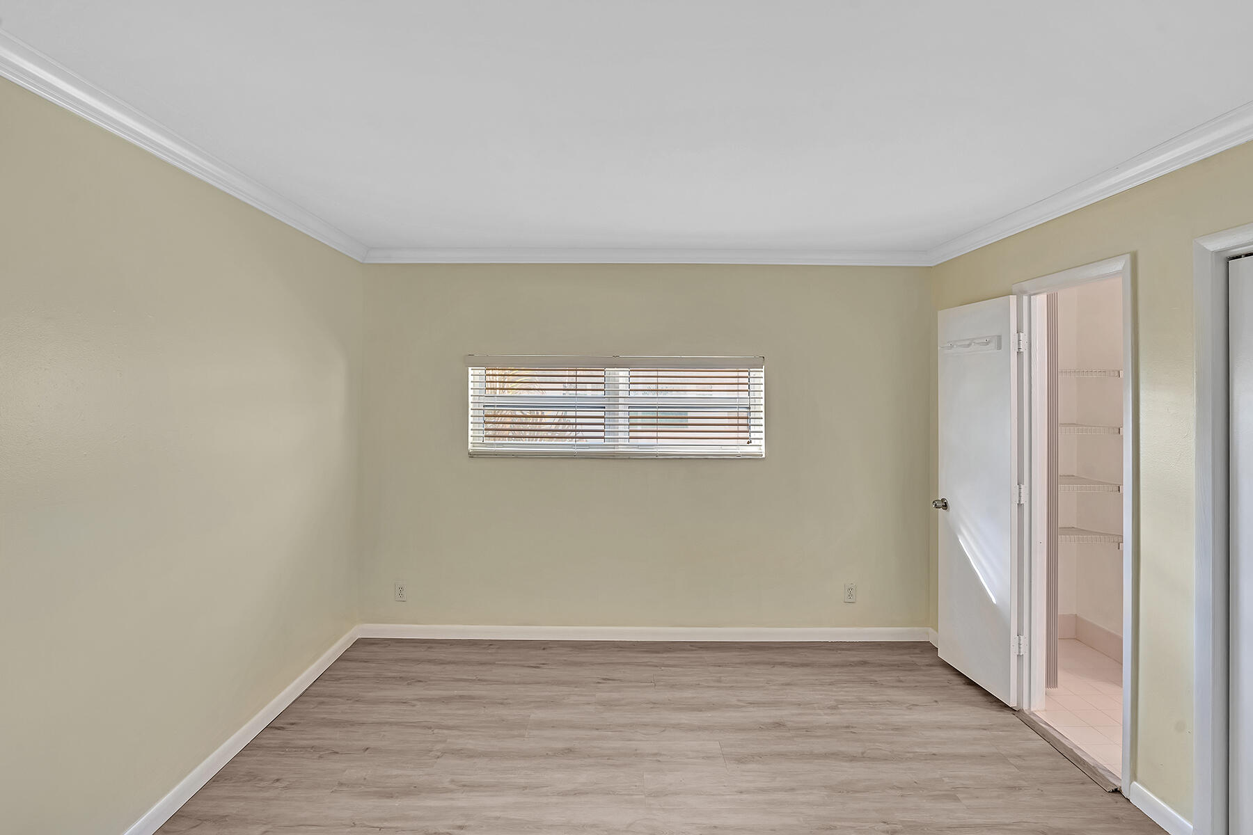 1945 Northwest 4th Avenue, Unit 32C Boca Raton, FL 33432 - Photo 36 of 52 a view of an empty room with wooden floor and a window