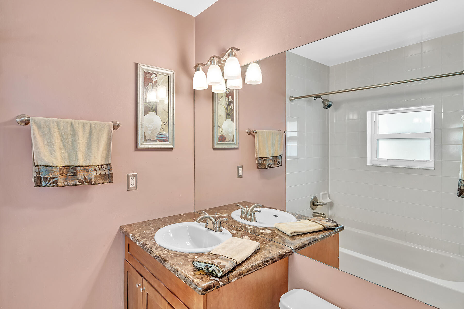 1945 Northwest 4th Avenue, Unit 32C Boca Raton, FL 33432 - Photo 42 of 52 a bath room with a sink mirror and a bath tub