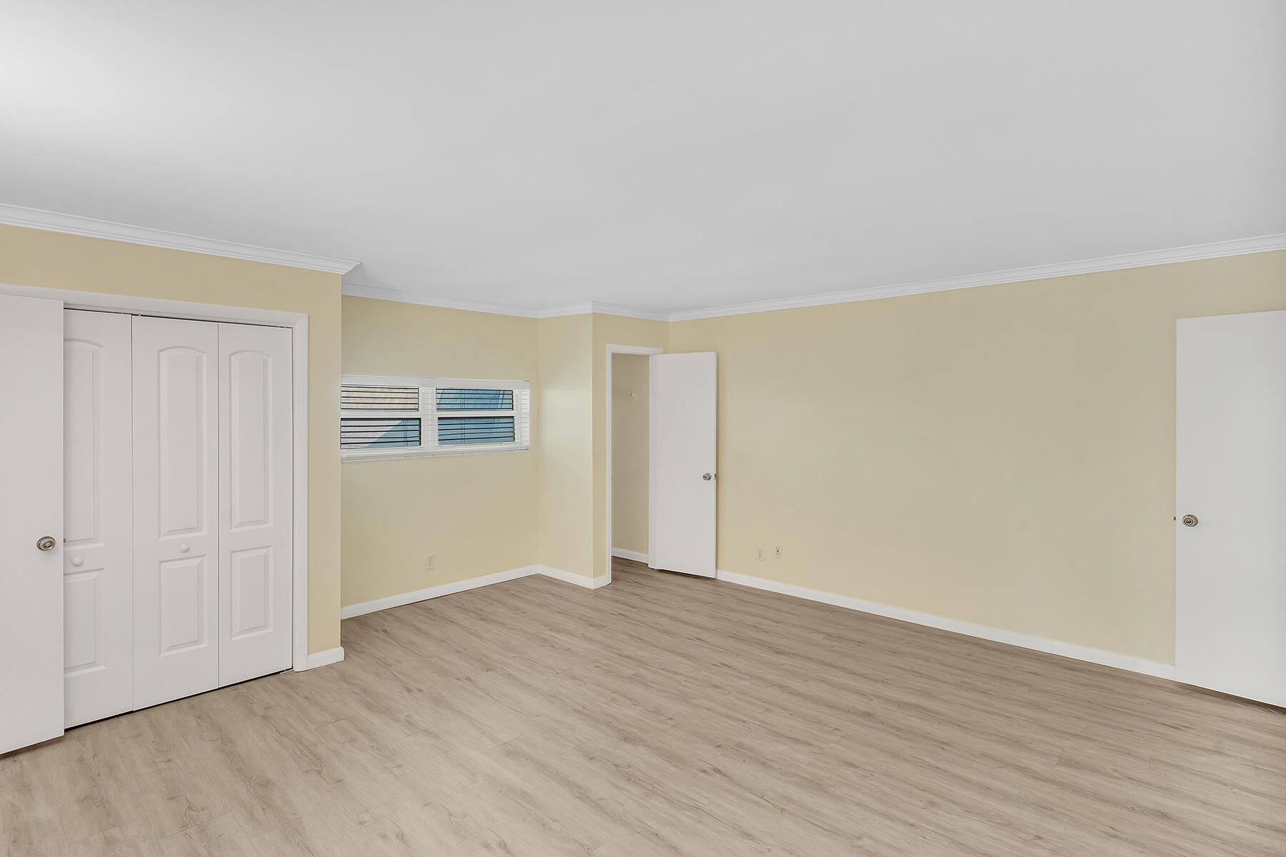 1945 Northwest 4th Avenue, Unit 32C Boca Raton, FL 33432 - Photo 43 of 52 a view of an empty room with wooden floor and a window