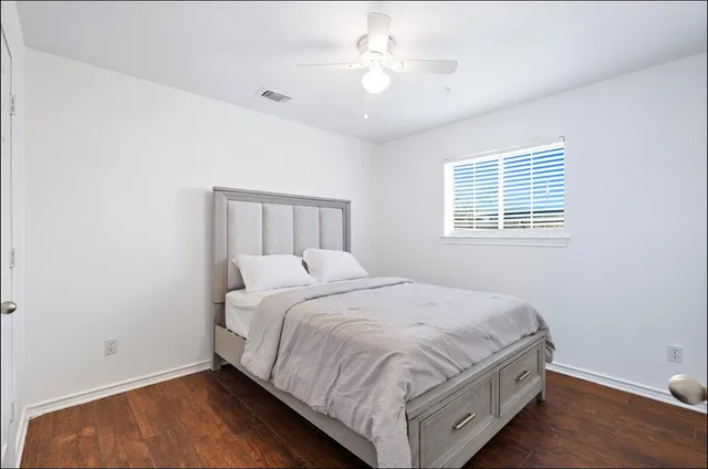a large bed sitting in a bedroom next to a window