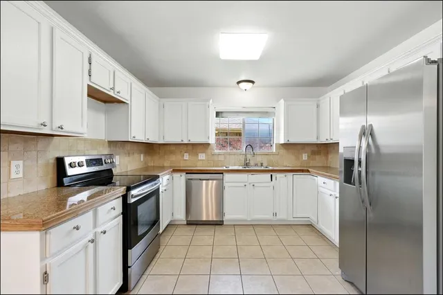 a kitchen with stainless steel appliances granite countertop a refrigerator sink and cabinets