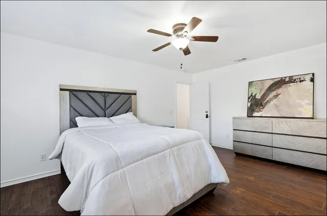 a bedroom with a bed and a painting on the wall