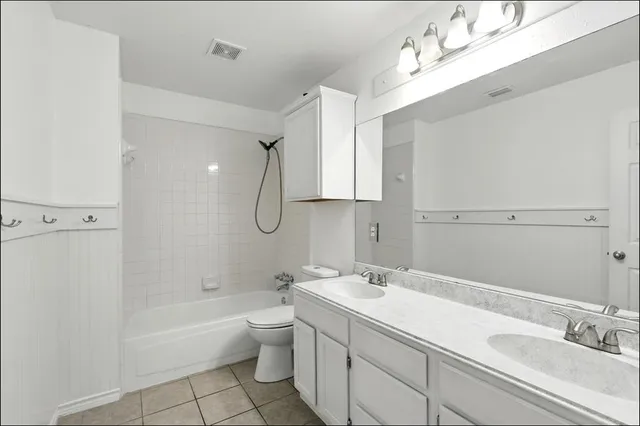 a bathroom with a sink double vanity granite tub shower and a mirror