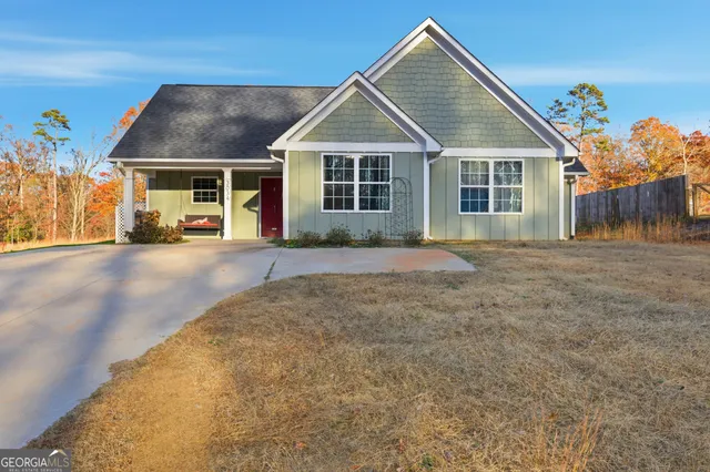a view of a house with a yard and potted plants