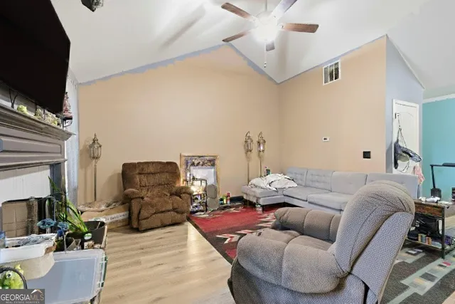 a living room with furniture a flat screen tv and a fireplace
