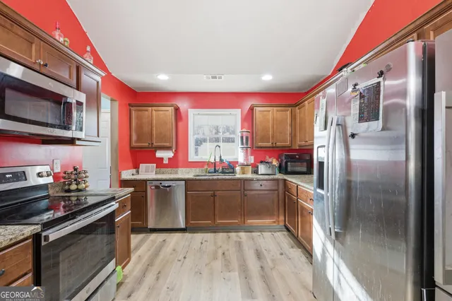 a kitchen with stainless steel appliances kitchen island granite countertop a stove sink and microwave