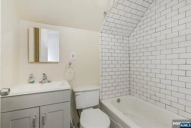a bathroom with a sink mirror toilet and bathtub