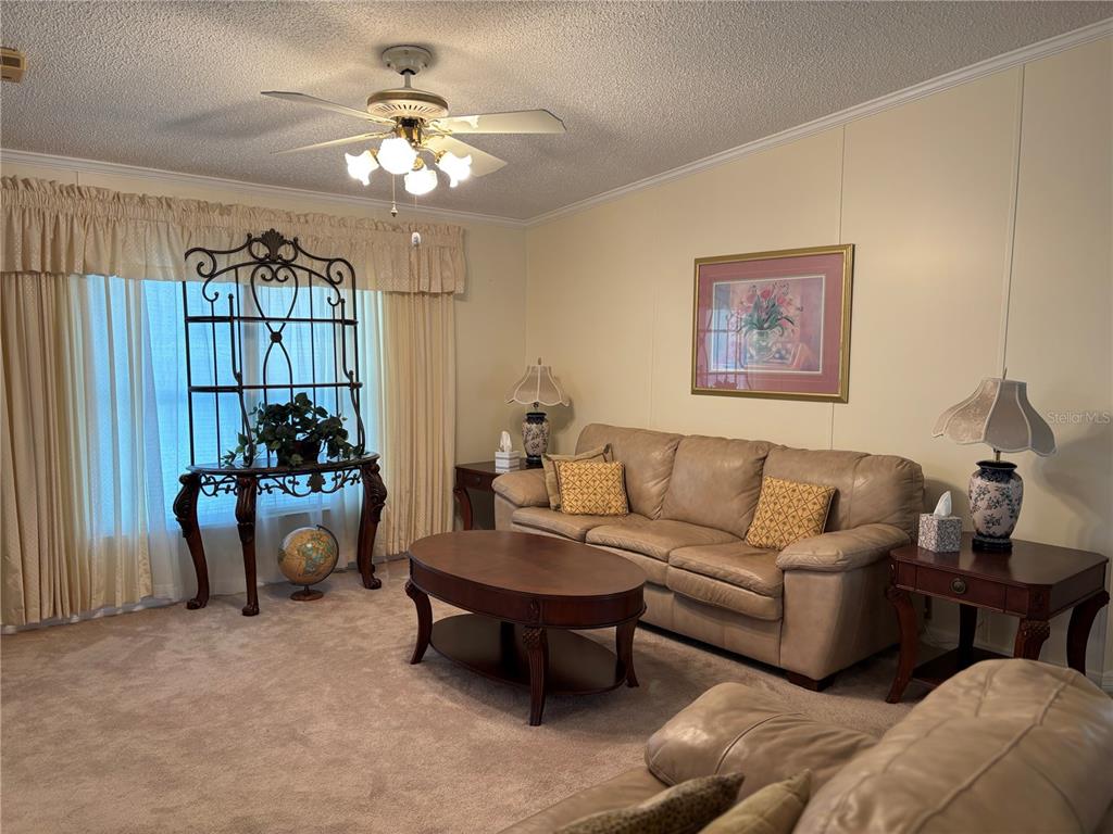 1759 Southwest 35th Circle Okeechobee, FL 34974 - Photo 6 of 29 a living room with furniture a chandelier and a window