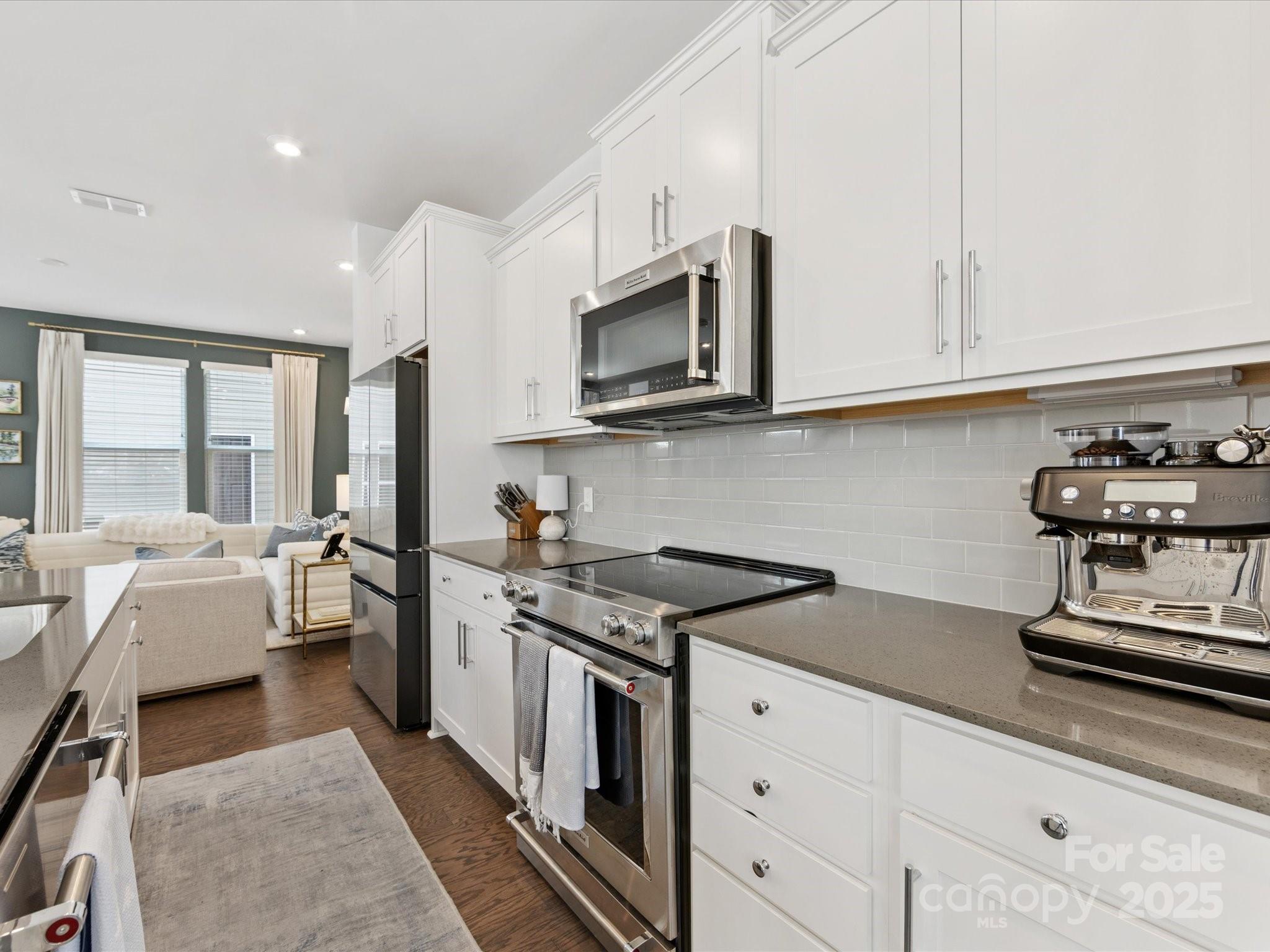 4027 Capital Ridge, Unit 10 Charlotte, NC 28205 - Photo 7 of 34 a kitchen with stainless steel appliances granite countertop a stove a sink dishwasher and a microwave oven with white cabinets