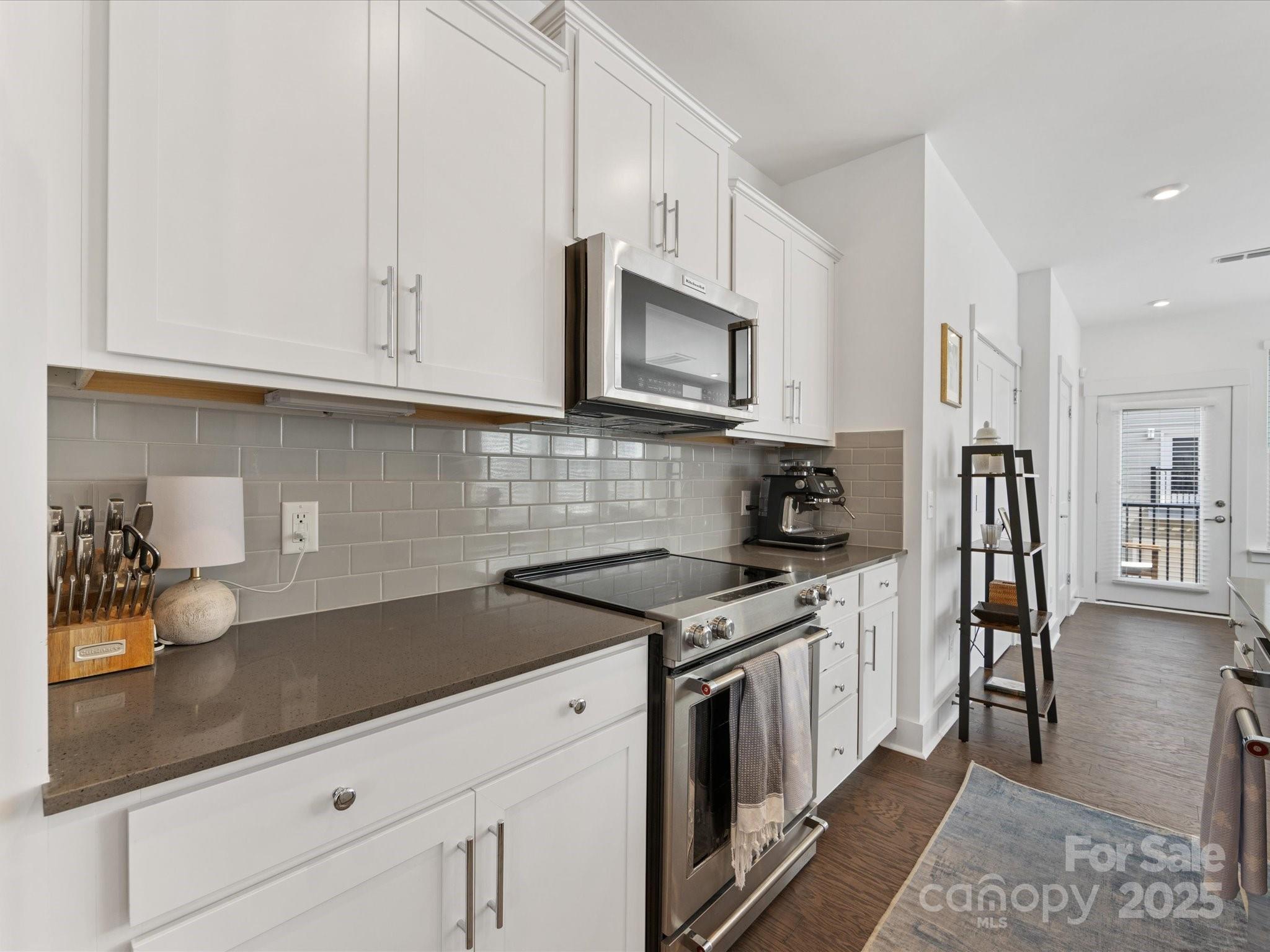 4027 Capital Ridge, Unit 10 Charlotte, NC 28205 - Photo 8 of 34 a kitchen with stainless steel appliances granite countertop a stove a sink and a white cabinets