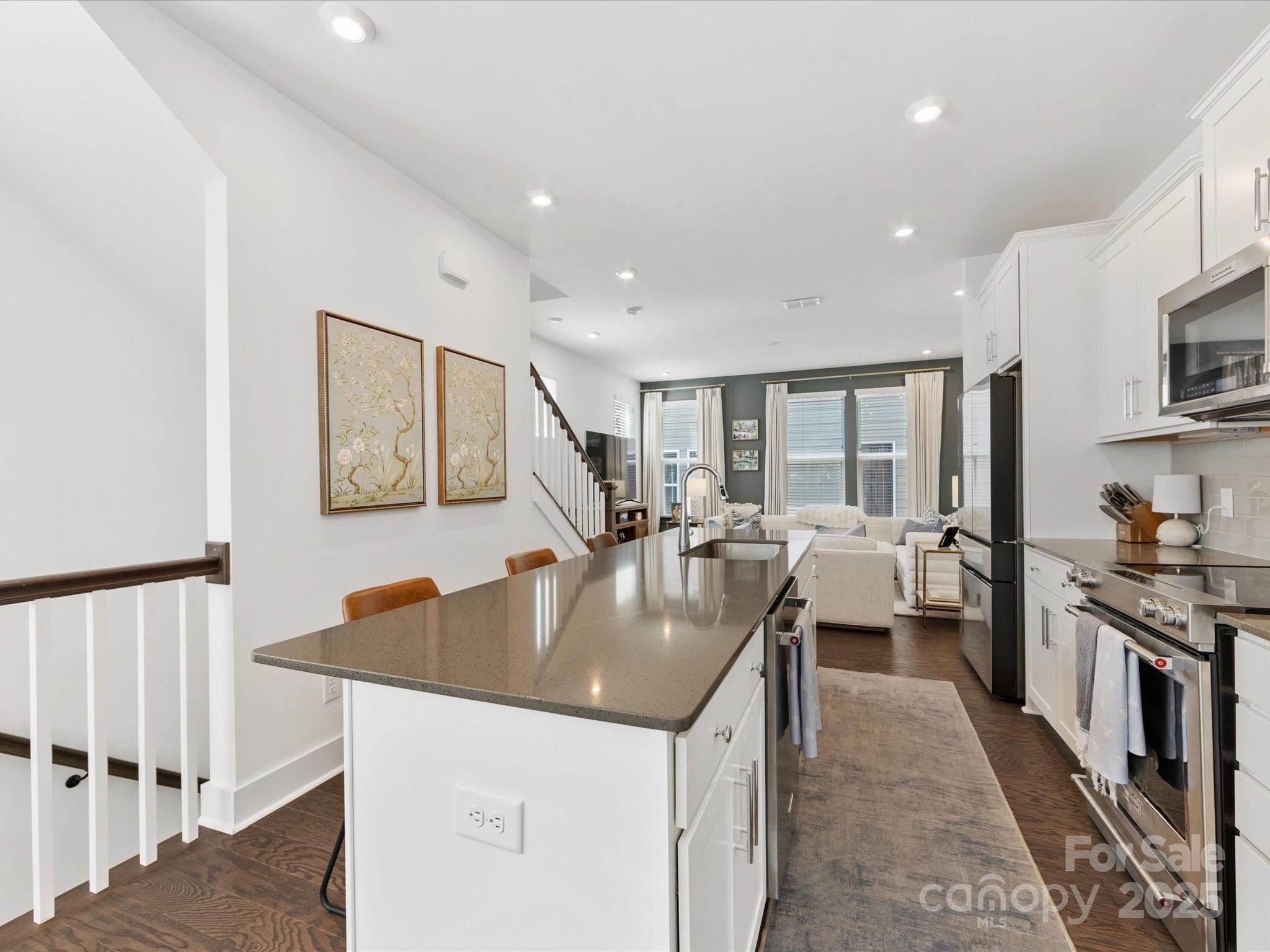 4027 Capital Ridge, Unit 10 Charlotte, NC 28205 - Photo 10 of 34 a large kitchen with stainless steel appliances granite countertop a lot of counter space and wooden floor