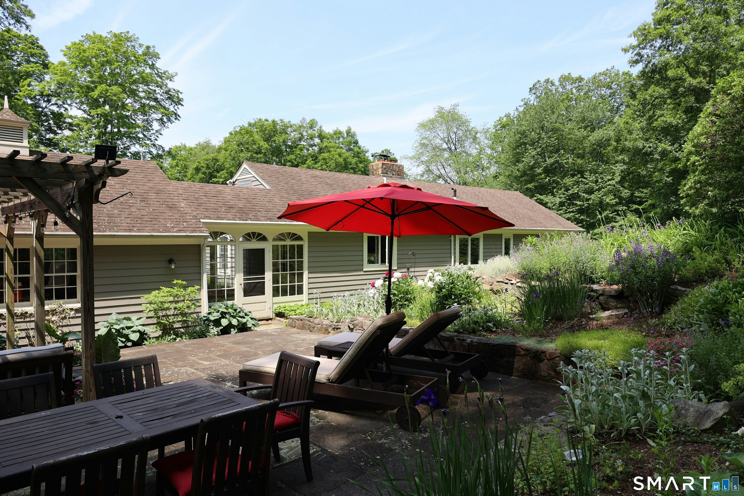 172 Gallows Hill Road Redding, CT 06896 - Photo 38 of 40 a view of a house with backyard sitting area and garden