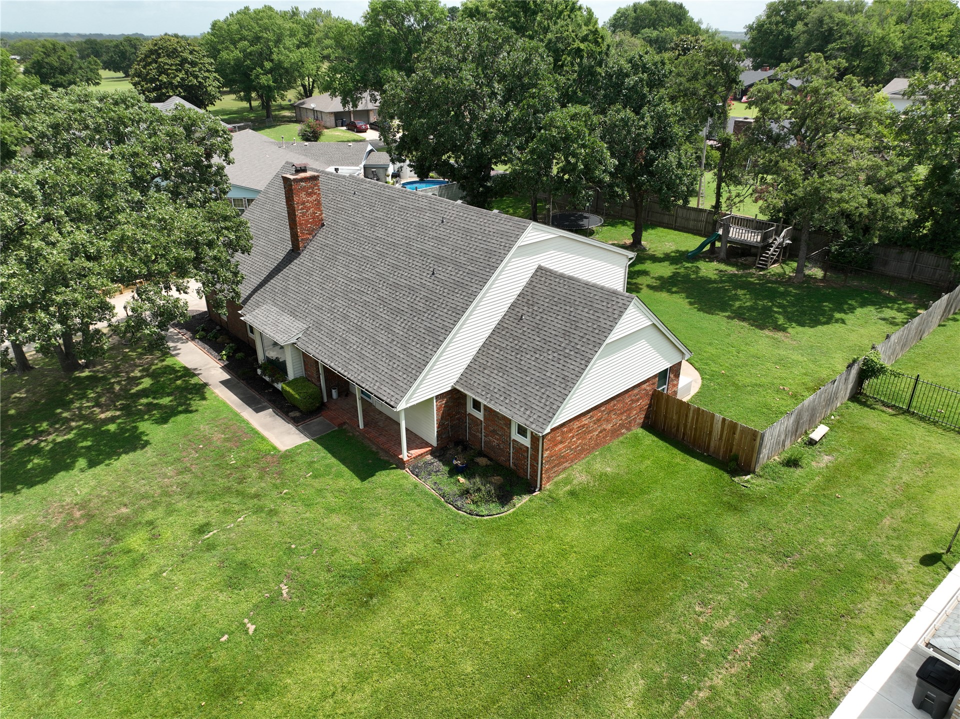 18 Dove Tree Road Wewoka, OK 74884 - Photo 54 of 65 Traditional brick residence featuring a gray shingle roof and a prominent chimney