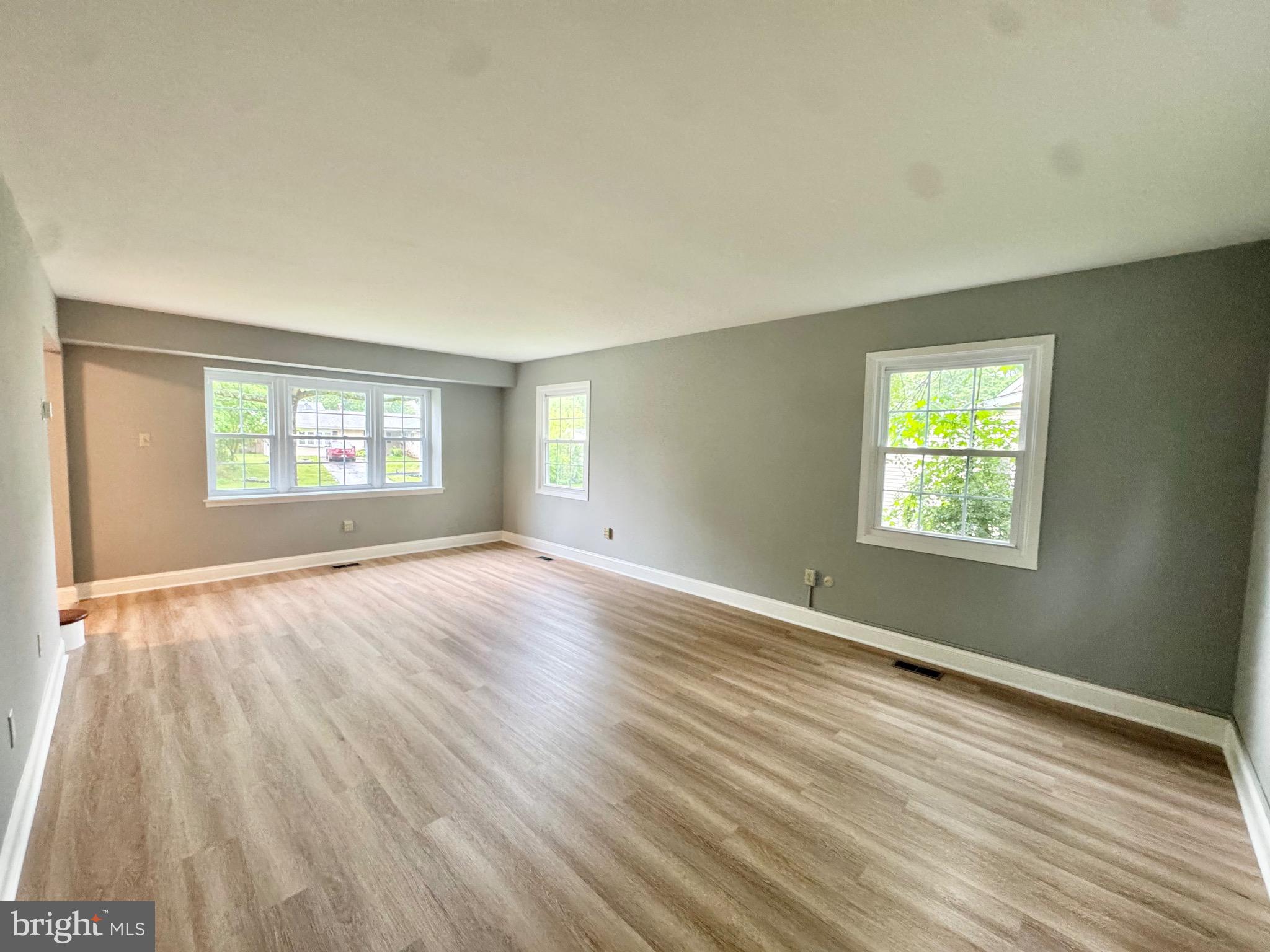 4908 Rocky Spring Lane Bowie, MD 20715 - Photo 4 of 36 a view of an empty room with wooden floor and a window