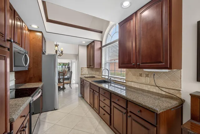 a kitchen with stainless steel appliances granite countertop a refrigerator and a sink