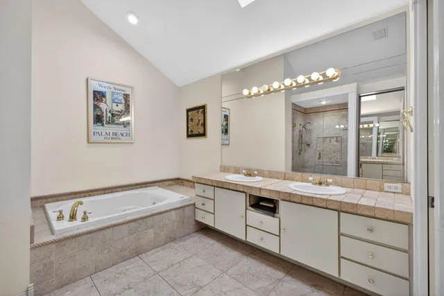 a spacious bathroom with a tub shower sink and mirror