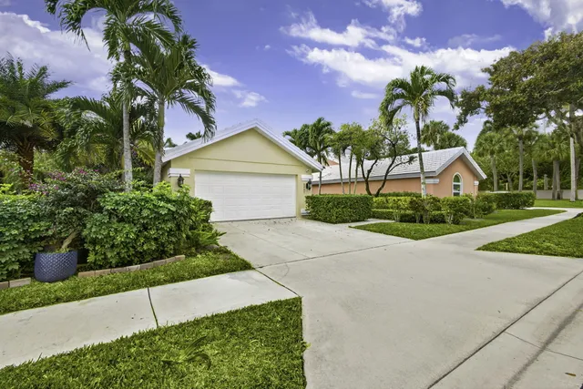 a front view of a house with a yard and potted plants