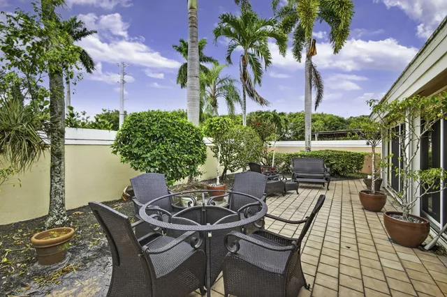 a view of a patio with table and chairs and potted plants