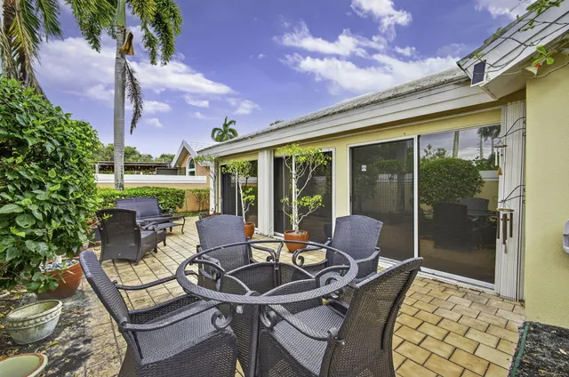 a view of a patio with table and chairs and potted plants