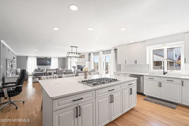 a kitchen with stainless steel appliances kitchen island granite countertop a sink stove and refrigerator