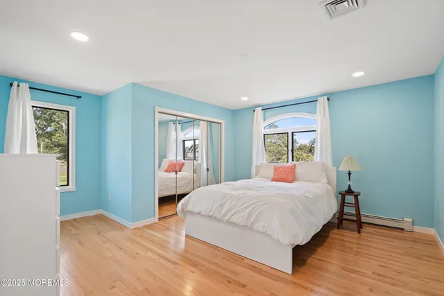 a bedroom with a large bed and a flat tv screen on dresser