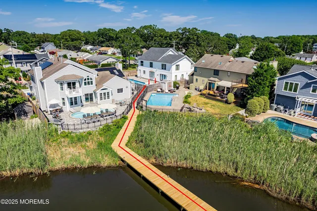 an aerial view of residential houses with outdoor space and lake view