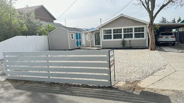 a view of a house with a backyard and parking space