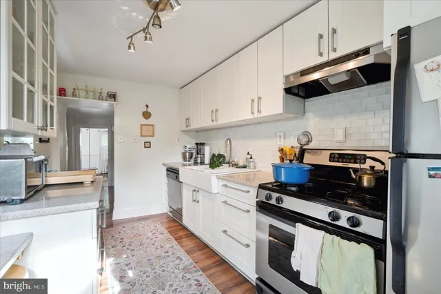 a kitchen with stainless steel appliances granite countertop a stove a sink and a refrigerator