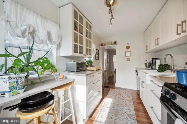 a kitchen with stainless steel appliances a stove a cabinets and wooden floor